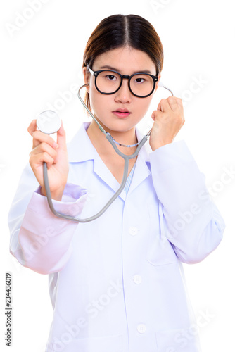 Studio shot of young beautiful Asian woman doctor using stethosc photo