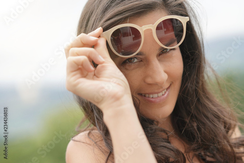 Portrait of smiling brunette woman wearing sunglasses
