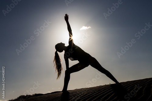 Woman doing yoga pose in back lit © Juan Algar