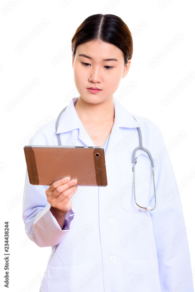 Studio shot of young beautiful Asian woman doctor holding digita Studio shot of young beautiful Asian woman doctor holding digita