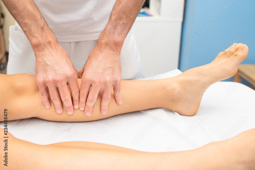 Fototapeta premium Leg treatment of an athlete by a physiotherapist