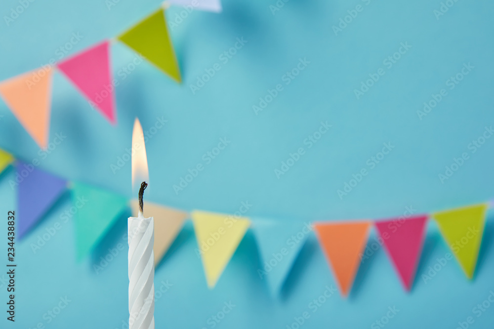 Candle on blue background with bunting