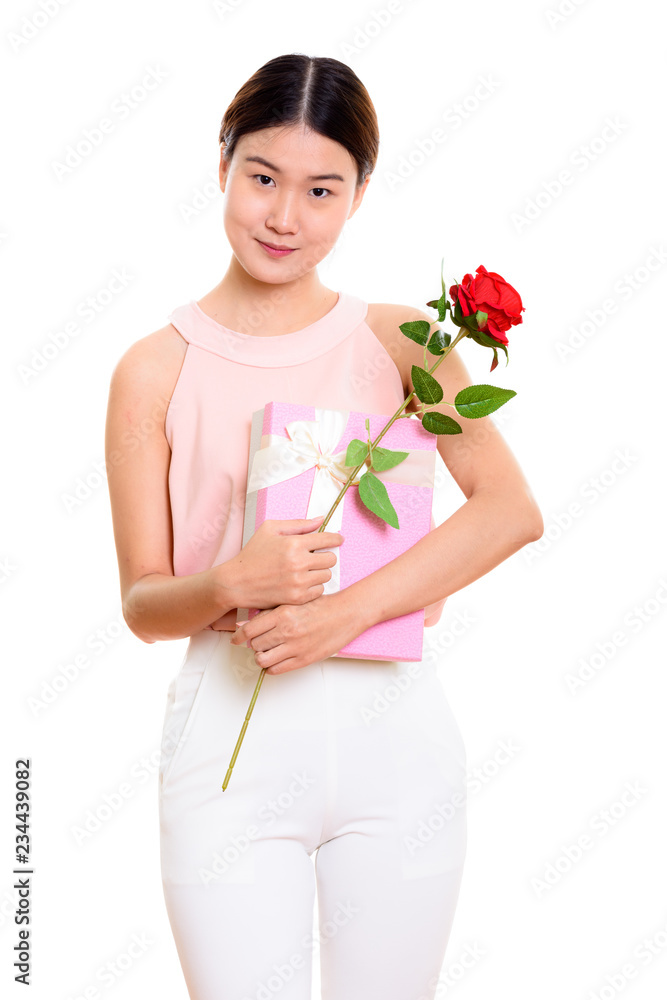 Young beautiful Asian woman holding red rose and gift box ready Young beautiful Asian woman holding red rose and gift box ready