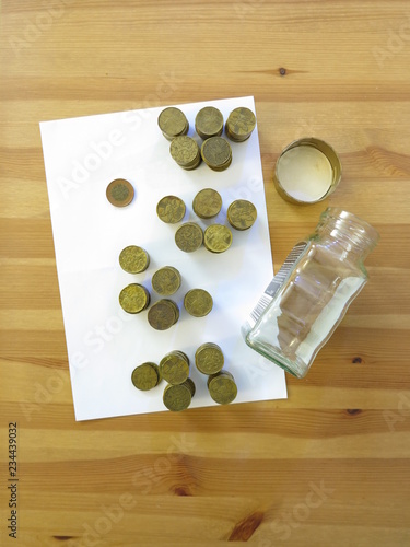 Coins from glass money box on the table