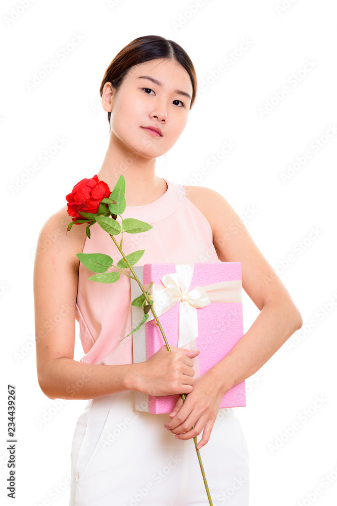 Young beautiful Asian woman holding red rose and gift box ready Young beautiful Asian woman holding red rose and gift box ready