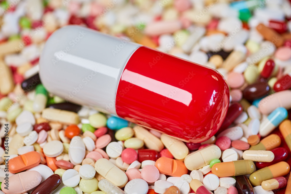 Große Pille und viele bunte Medikamente Stock-Foto | Adobe Stock