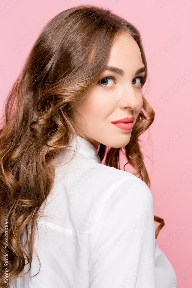 Happy business woman standing and smiling isolated on pink studio background. Beautiful female half-length portrait. Young emotional woman. The human emotions, facial expression concept Happy business woman standing and smiling isolated on pink studio background. Beautiful female half-length portrait. Young emotional woman. The human emotions, facial expression concept