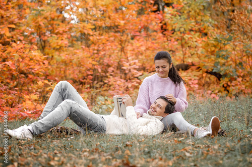 couple in love sitting in autumn park and reading book © producer