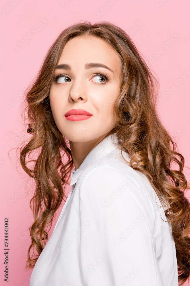 Portrait of young woman arrogantly looking in camera isolated on pink studio background Portrait of young woman arrogantly looking in camera isolated on pink studio background