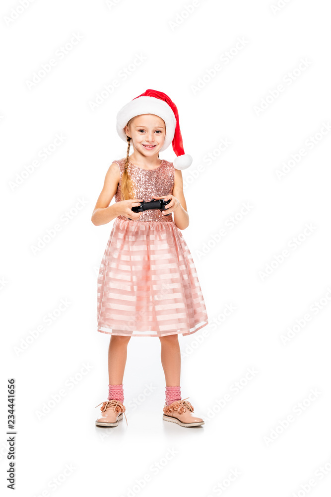 happy little child in santa hat playing video game and looking at camera isolated on white happy little child in santa hat playing video game and looking at camera isolated on white