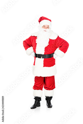 santa claus looking at camera with arms akimbo isolated on white