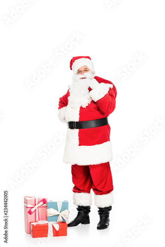 santa claus with gift boxes and bag looking at camera isolated on white