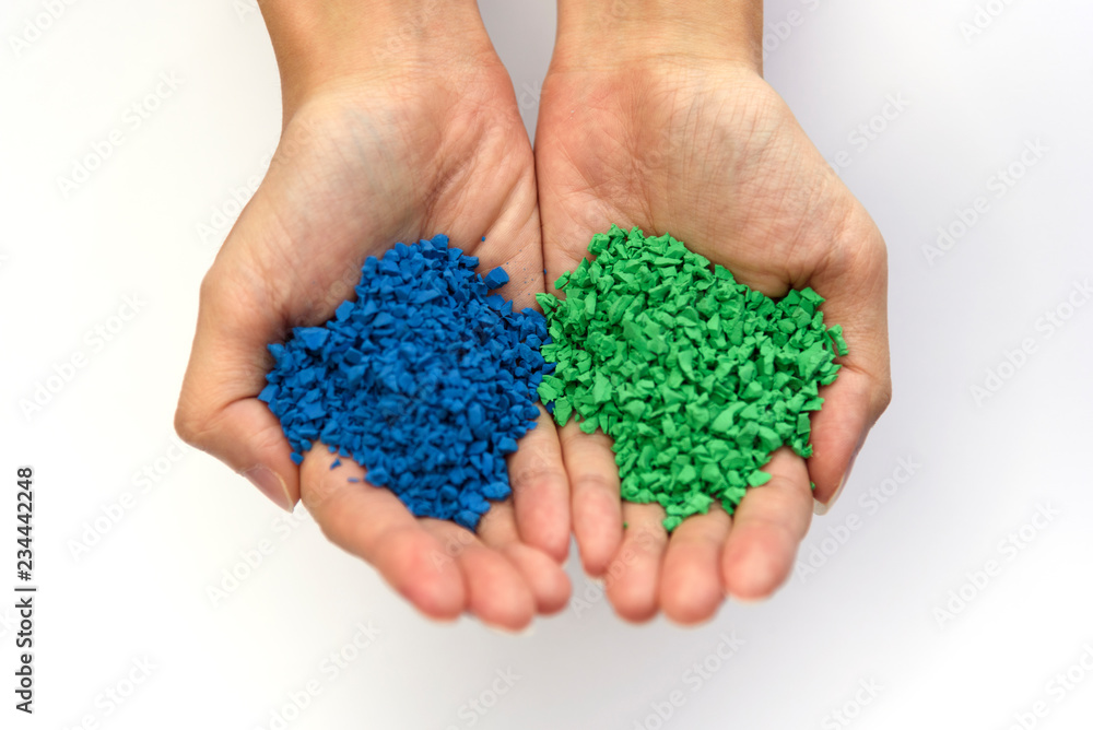 Hands holding small pieces of rubber, blue and green. Hands holding small pieces of rubber, blue and green.