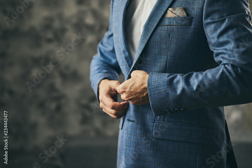 Businessman wears a jacket,male hands closeup,groom getting ready in the morning before wedding ceremony