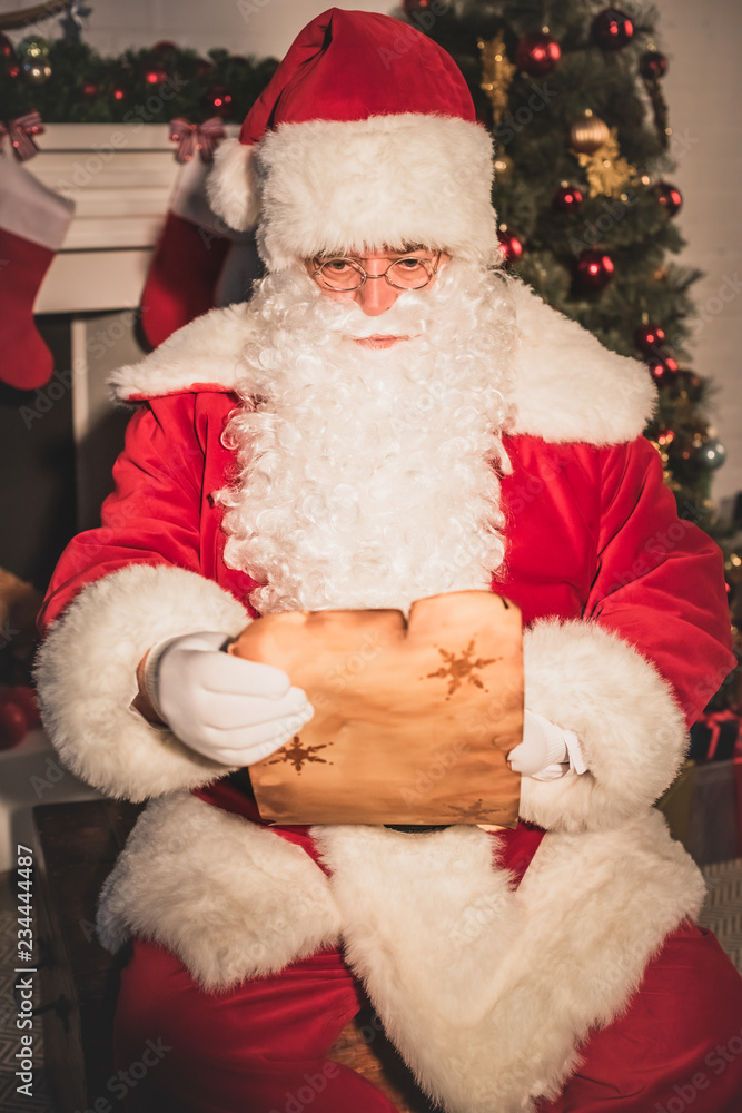 santa claus holding parchment and reading wish list santa claus holding parchment and reading wish list