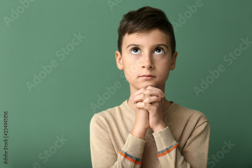 Little boy praying on color...