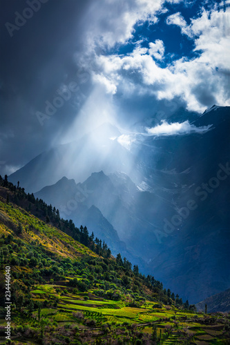 Sun rays through clouds in Himalayan valley in Himalayas