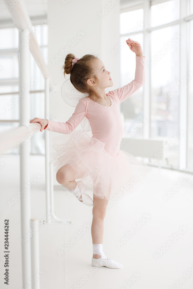 Little ballerina girl in a pink tutu. Adorable child dancing classical  ballet in a white studio. Children dance. Kids performing. Young gifted  dancer in a class. Preschool kid taking art lessons Stock