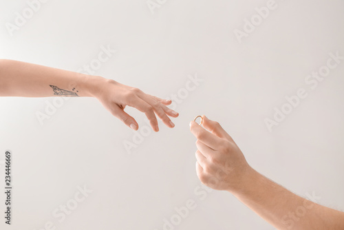 Man putting engagement ring...