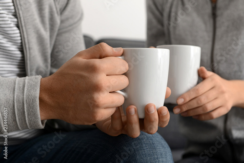Young couple with cups of tea  closeup