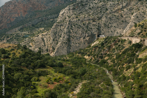 Views of a large valley in Ardales, Andalusia, surrounded by mountains and a train that goes through the mountain tunnel.