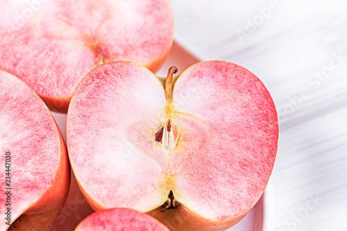 Tablou pe pânză Apples with pink flesh on a light background