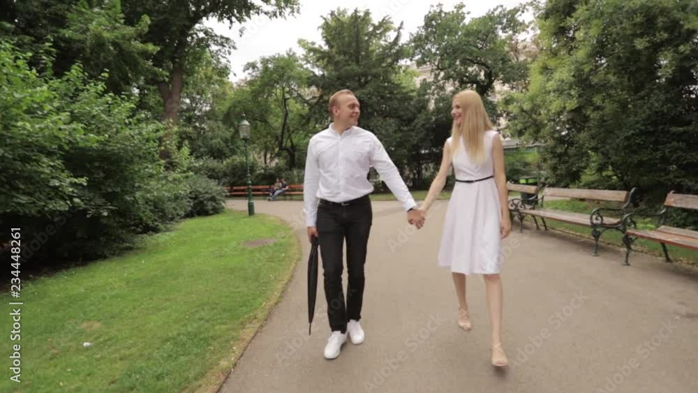 Young couple walking in the park. The have fun and rejoice. Black and white clothes Young couple walking in the park. The have fun and rejoice. Black and white clothes
