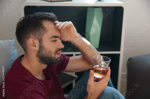 Drunk young man with glass ...