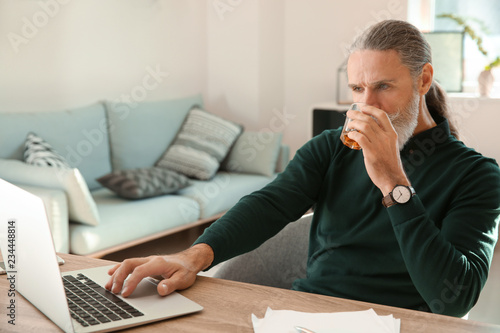 Senior man drinking whiskey...