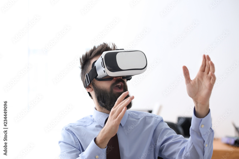 Businessman wearing virtual reality glasses in office Businessman wearing virtual reality glasses in office