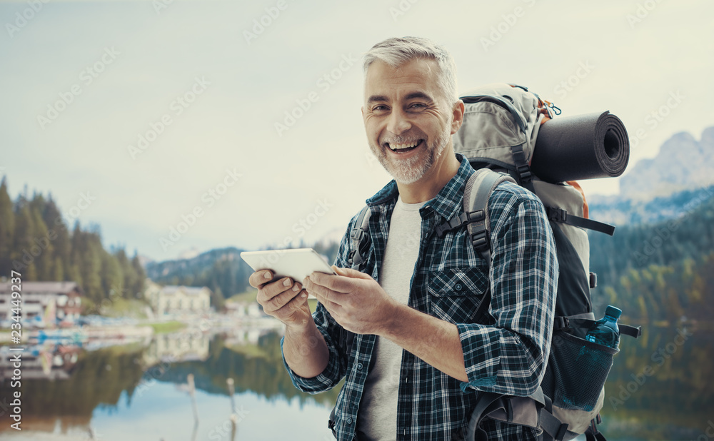 Obraz premium Hiker connecting with a tablet