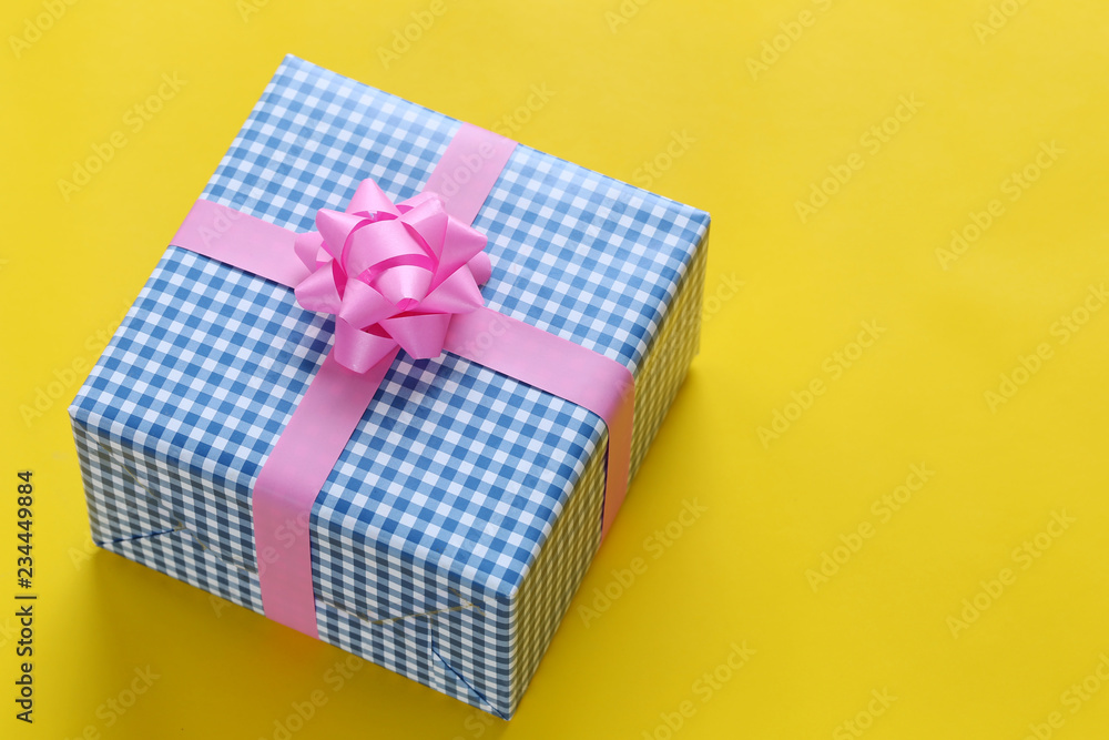 Obraz premium Blue Christmas gift box placed on a yellow art paper floor and have copy space.