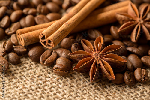 Coffee beans, anise and cinnamon on brown burlap. Close up