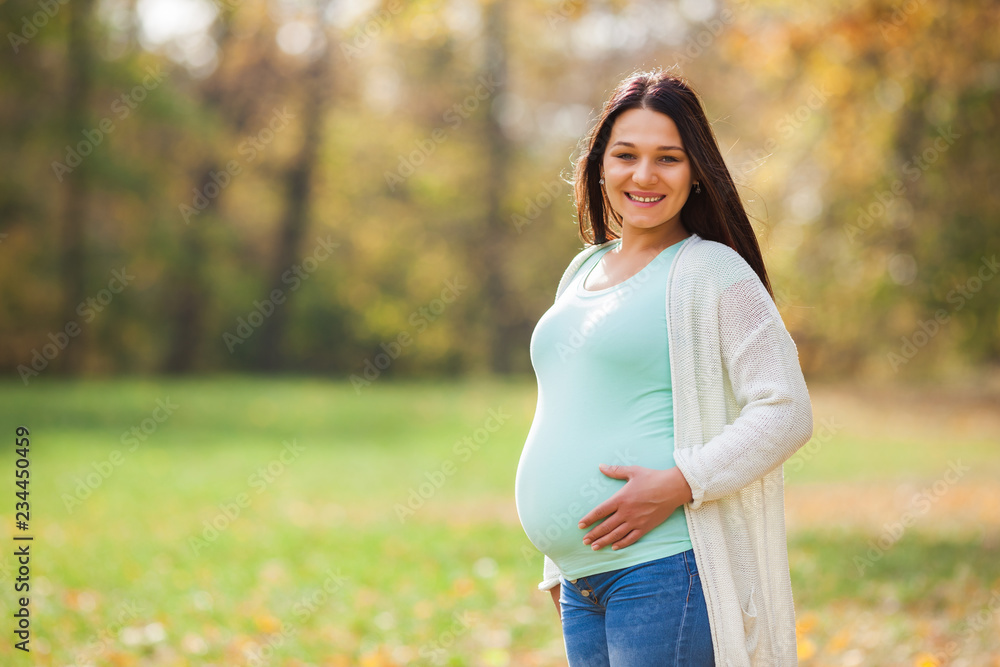 Happy pregnant woman relaxing in park. Happy pregnant woman relaxing in park.