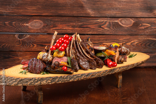 Mixed Grilled meat and vegetables on wooden background photo