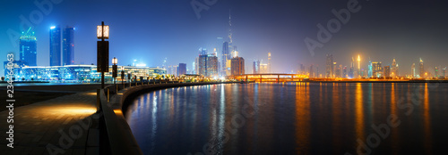 Beautiful HD panoramic view to Dubai downtown city center skyline from Design District promenade at night, United Arab Emirates