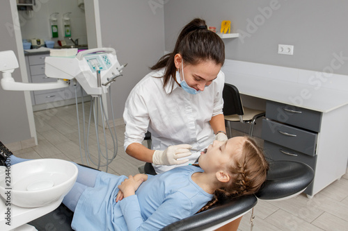 Child having dental check up by specialist in dentist office