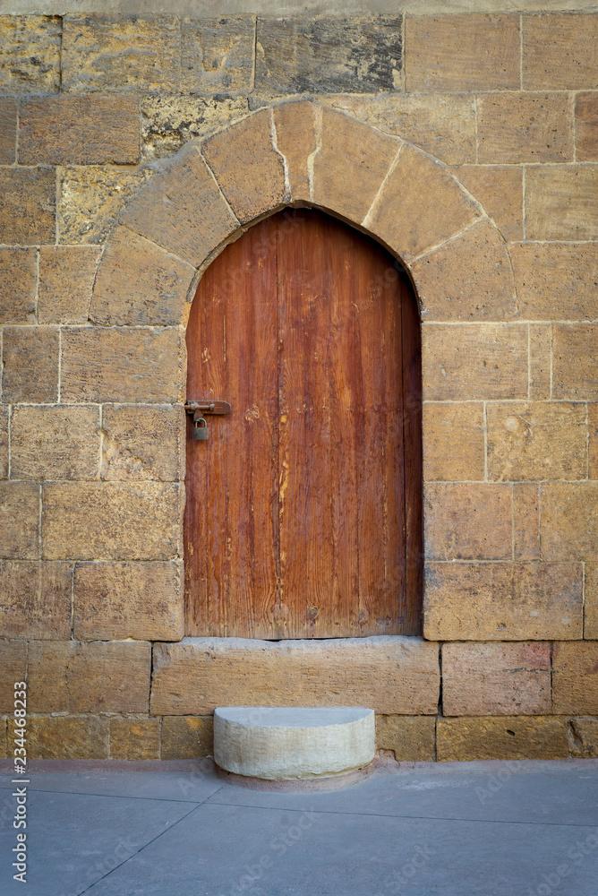 Old wooden door and window framed by arched bricks stone wall at the courtyard of al Razzaz historic house, Darb al Ahmar district, Old Cairo, Egypt Old wooden door and window framed by arched bricks stone wall at the courtyard of al Razzaz historic house, Darb al Ahmar district, Old Cairo, Egypt