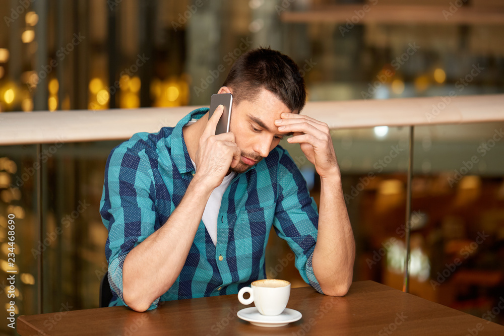 people, communication and leisure concept - man drinking coffee at restaurant and calling on smartphone people, communication and leisure concept - man drinking coffee at restaurant and calling on smartphone
