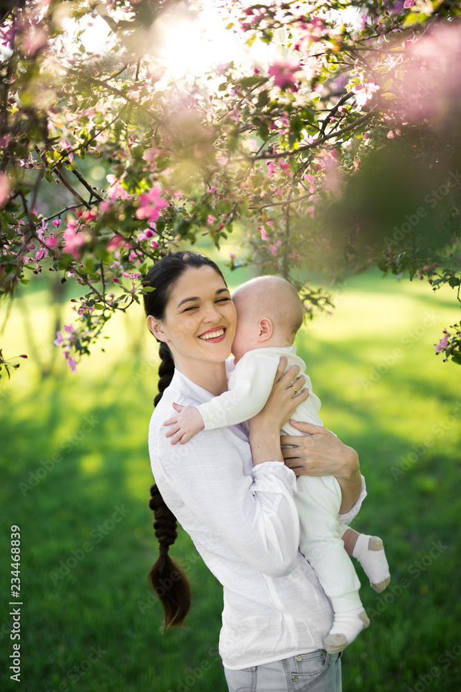 Portrait Beautiful Mother And Baby outdoors. Nature. Beauty Mum and her Child playing in Park Portrait Beautiful Mother And Baby outdoors. Nature. Beauty Mum and her Child playing in Park