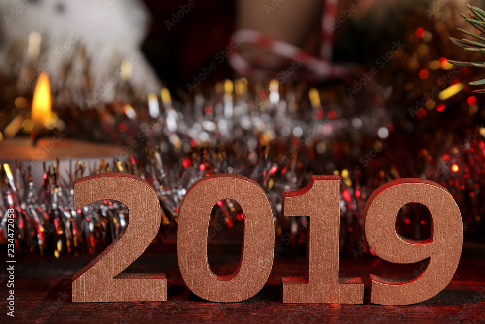 2019 figures in the foreground and New Year's decorations on a brown wooden background. new Year. Christmas. holidays