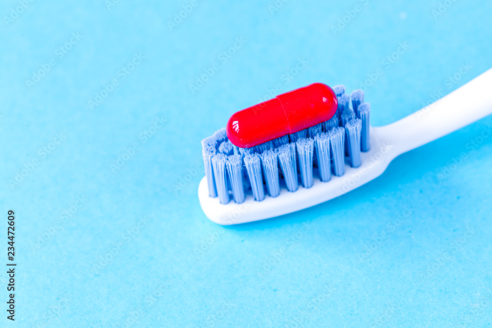 concept toothache with toothbrush and pills at blue background