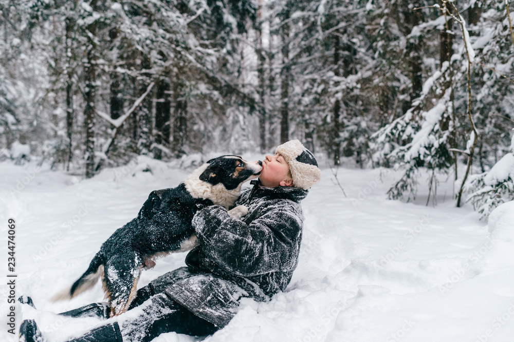 Country woman in winter padded jacket covered ins now hugging her belowved funny dog. Eccentric unusual girl sitting in snow in wood and playing with frozen puppy. Adult lady with pet walk in forest. Country woman in winter padded jacket covered ins now hugging her belowved funny dog. Eccentric unusual girl sitting in snow in wood and playing with frozen puppy. Adult lady with pet walk in forest.