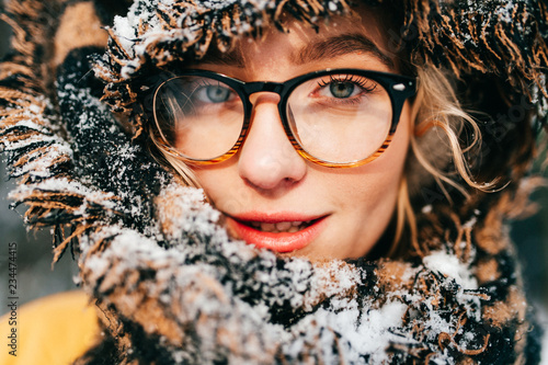 Unusual cute girl creative lifestyle fashion pottrait. Odd strange lovely funny woman in glasses. Graceful beatiful female smiling sensual face. Bizzare rebel lady wearing winter clothes. Snowy scarf. photo