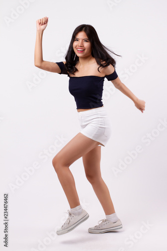 excited happy woman. portrait of asian walking, jumping or hopping woman studio white background isolated. excited happy people concept. young adult asian woman model