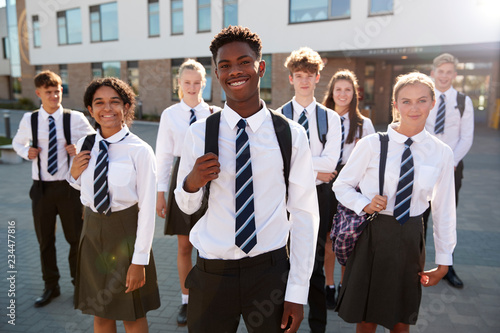 Portrait Of Smiling Male And Female High School Students Wearing Uniform Outside College Building photo