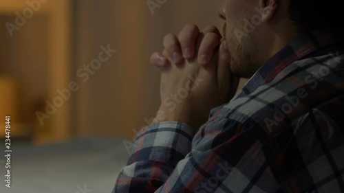 Sad man standing on knees and praying to God, problems in life, faith and hope