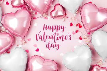 Air Balloons of heart shaped foil  on pastel pink background. Love concept. Holiday celebration. Valentine's Day or wedding/bachelorette party decoration. Metallic balloon