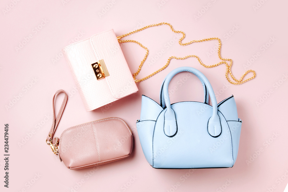 Fashion handbags on pale pink background. Flat lay, top view. Spring/summer fashion concept in pastel colored - obrazy, fototapety, plakaty 