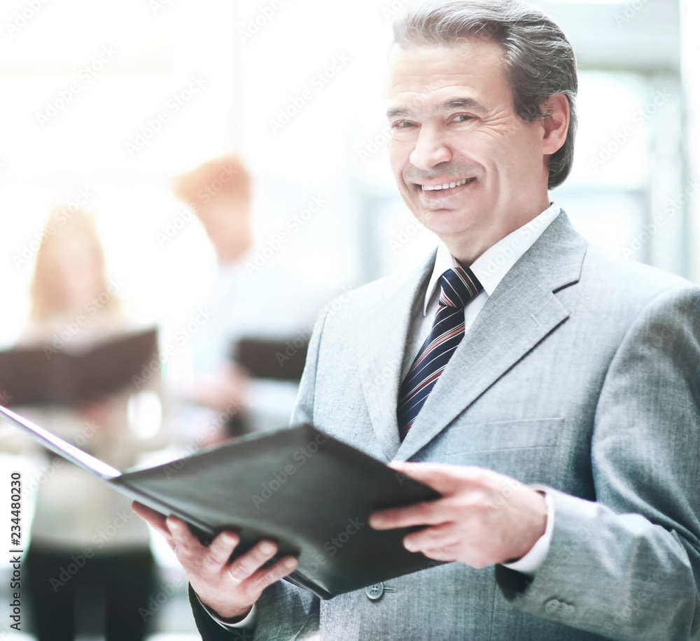 successful businessman with documents on the background of the modern office successful businessman with documents on the background of the modern office